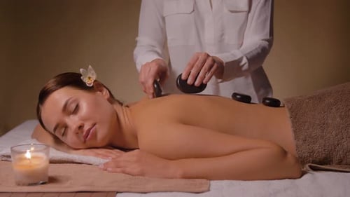 Belle femme ayant un massage aux pierres chaudes au spa