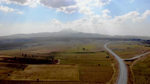 Aerial View of Rural Road and Distant Mountains