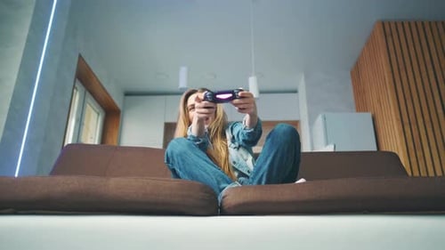 Woman Enjoying Video Game on Couch at Home
