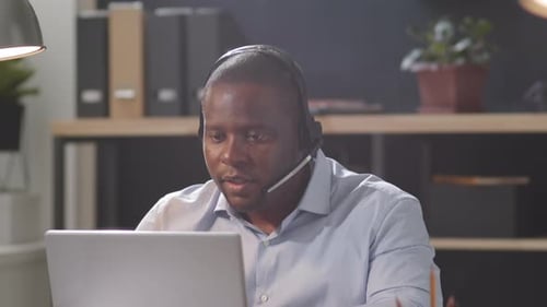 Afro-American Call Center Worker Speaking on Web Call on Laptop