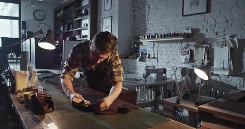 Männlicher Handwerker mit Lederschneider