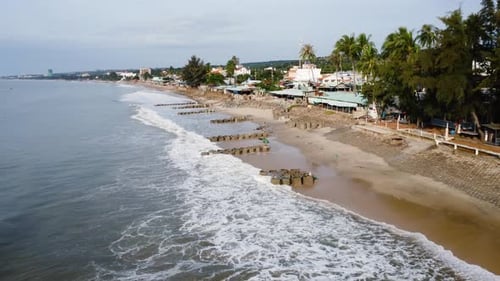 Vietnam coastal town and sandbags to stop beach erosion, aerial drone view