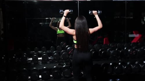 Gym Training Young Woman Lifting Dumbbells and Training Her Hands
