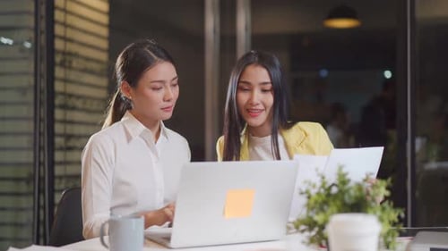 Asian young business man and woman people group have discussion meeting in office at night time.