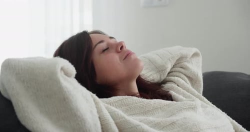 Woman Relaxing on Couch in Comfortable Home