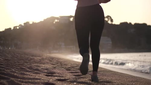 Active Woman Jogging on Sandy Beach at Sunrise