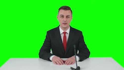 Man Talking at Desk with Green Screen Background