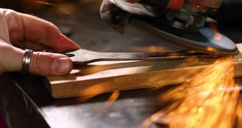 Close up Locksmith works with grinder machine, fly bright sparks