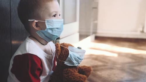 Child with Mask Holding Teddy Bear Toy