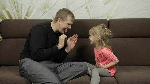 Happy Father and Child Playing on Sofa