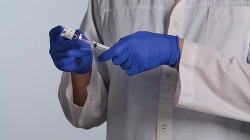 Medical Professional Fills Syringe with Vaccine Solution