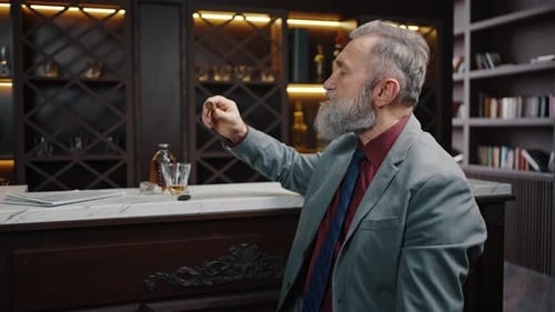 Senior Man with Cigar Sitting at Bar