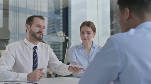Rear Back View of Guy Getting Documents From Executive Business People