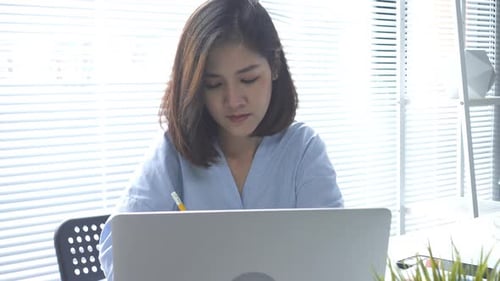 Woman Working on Laptop in Bright Office