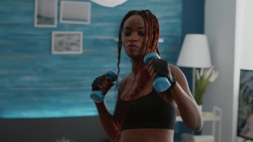 Woman Shadow Boxing with Dumbbells in Living Room