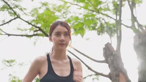 Asian young beautiful sport athlete woman exercise by running outdoor on street in public park.
