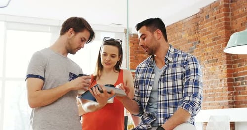 Team Discussing Project on Tablet in Office