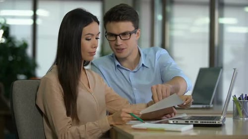 Business Professionals Reviewing Charts in Modern Office