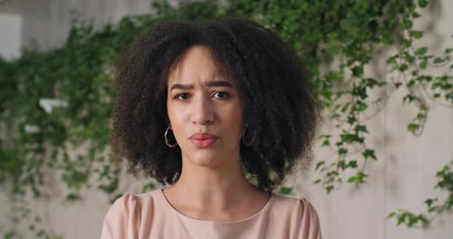 Front Portrait of Disgruntled African American Woman with Stylish Curls Looking at Camera Sadly