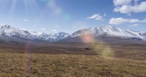 Timelapse of Sun Movement on Crystal Clear Sky with Clouds Over Snow Mountain Top