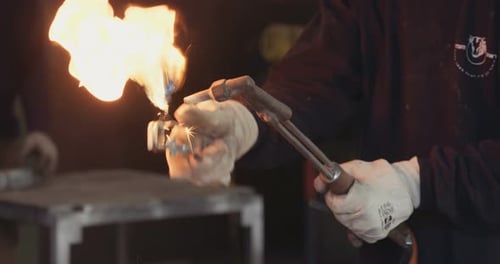 Worker lighting up a tourch in a metal workshop