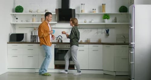 Friends Laugh and Dance in a Bright Kitchen