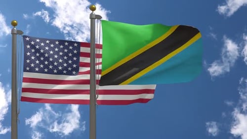 United States and Tanzania Flags Waving Against Blue Sky