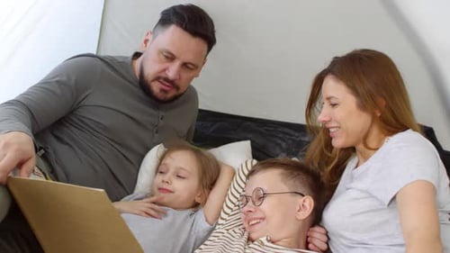 Family Reading a Story Together Inside a Tent