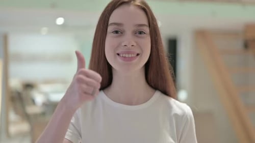 Smiling Young Woman Gives a Thumbs Up