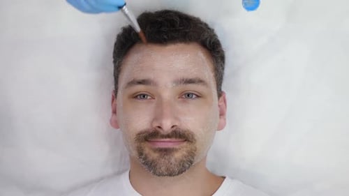 Man Receiving a Cosmetic Face Mask Treatment