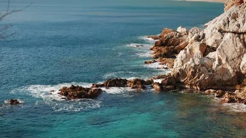 Klares türkisfarbenes Meerwasser bricht auf einer felsigen