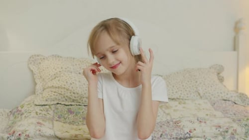 Girl Enjoying Music with Headphones in Bedroom
