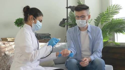Doctor Checks Patient Pulse with Stethoscope During Checkup