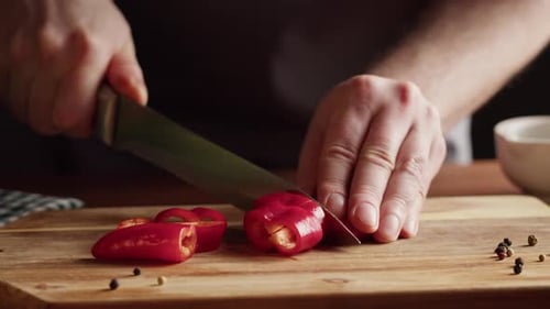 Slicing Red Pepper on a Wooden Board