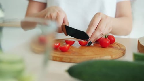 Close-up Slow Motion of Female Hand Chopping Tomatoes of Wooden Cutting Board