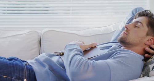 Man Sleeping on a Couch with a Book
