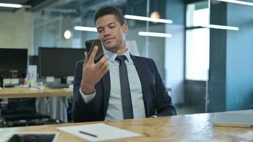 Young African Businessman Using Smartphone in Office