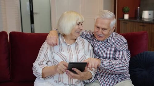 Loving Senior Couple Enjoying Tablet at Home
