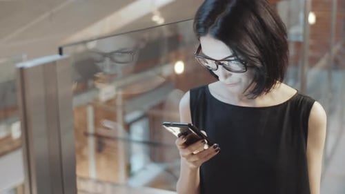 Business Lady Texting on Smartphone in Office