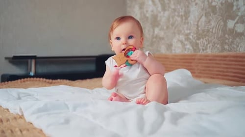 Adorable Baby Playing with Wooden Toy on Bed