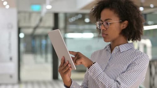 Woman Using Tablet in Modern Office Setting