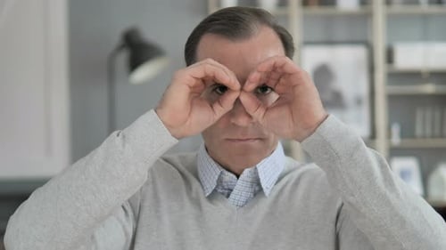 Man Makes Binocular Shape with Hands
