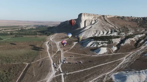Four Balloons Take Off in the Sky at Dawn Against a White Rock Crimea White Rock August 2019