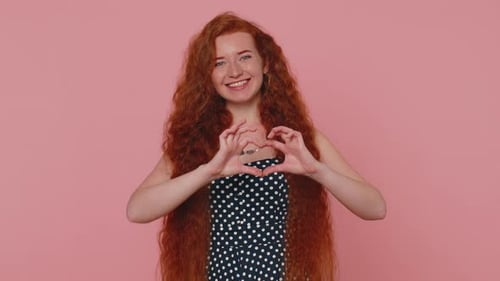Woman Smiling and Making Heart Shape With Hands