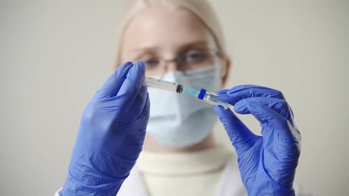 Medical Professional Filling Syringe with Vaccine