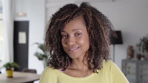 Smiling Woman with Curly Hair Poses Indoors