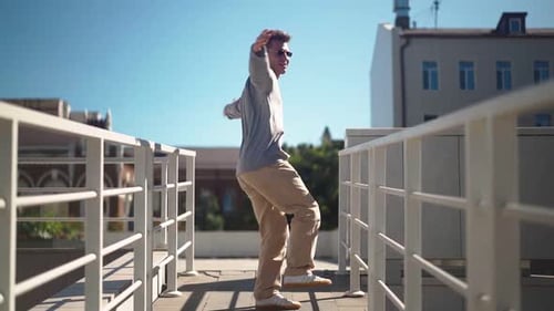 Handsome Happy Man Is Actively Running Smiling and Dancing with Joy and Happiness Along City Street