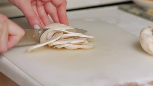Woman Slicing Fresh Mushroom on Cutting Board