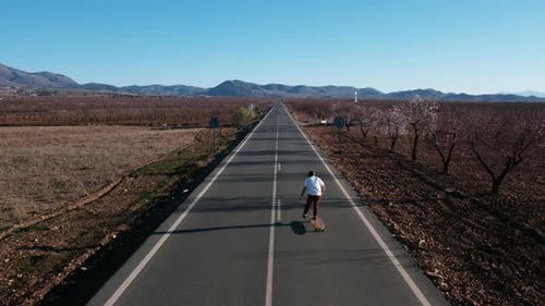 Aerial Dolly Drone Shot of Solo Man Ride Longboard