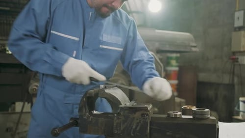 One professional Asian male worker works in metalwork manufacturing factory.